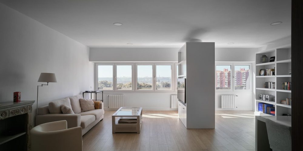 Salón con librería empotrada y ventanal a la ciudad, en la vivienda de Santa Fe
