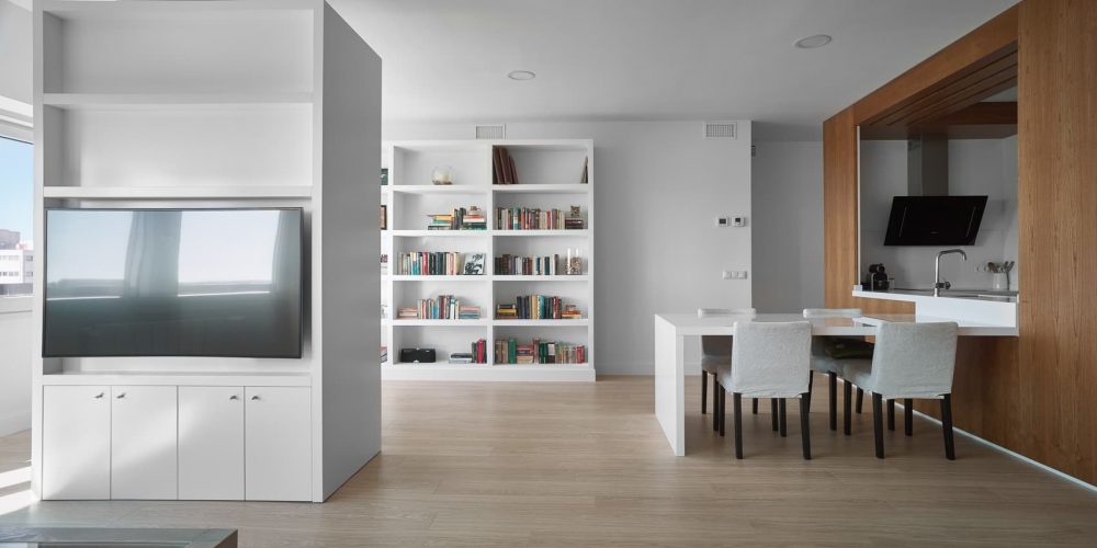 Salón con librería empotrada, televisor y comedor, en la vivienda de Santa Fe