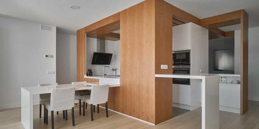 Cocina y comedor articulados por un volumen de madera en la vivienda de Santa Fe