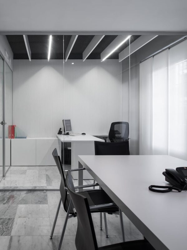 Sala de reuniones acristalada con mesa alargada, en las oficinas de ApiBurgos