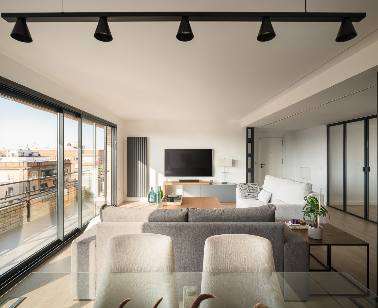 Salón con ventanal corrido y vistas a la ciudad, en la reforma de la vivienda de La Borbolla