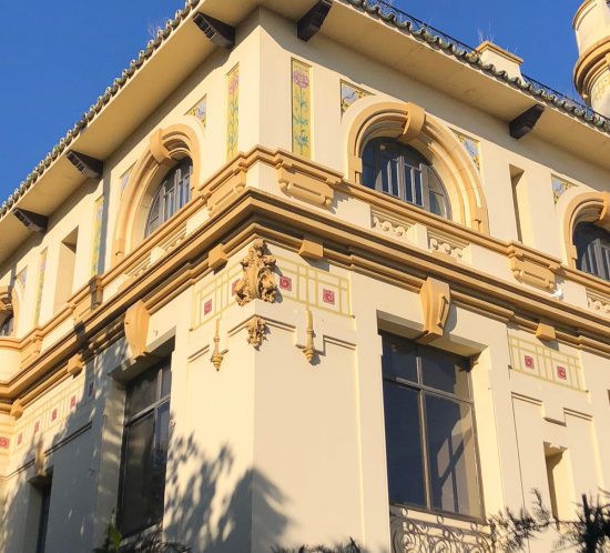 Esquina superior de un edificio histórico con molduras y azulejos decorativos