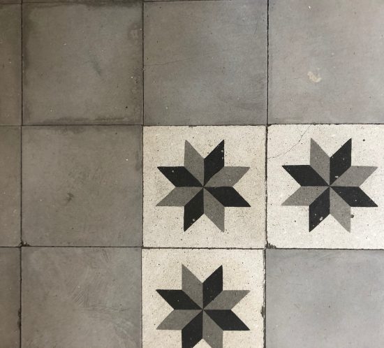 Detalle del suelo de baldosa antigua con estrellas de ocho puntas