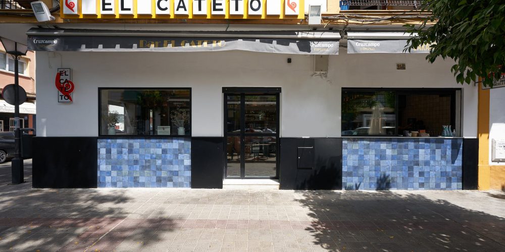 Rótulo El Cateto sobre el zócalo de azulejos azules de la fachada