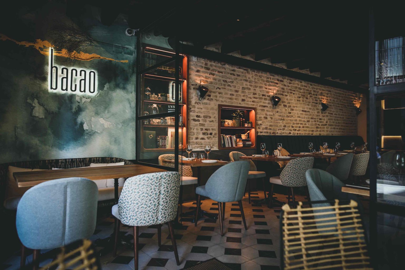 Comedor con mural, muro de ladrillo y suelo de espiga, en el restaurante Bacao