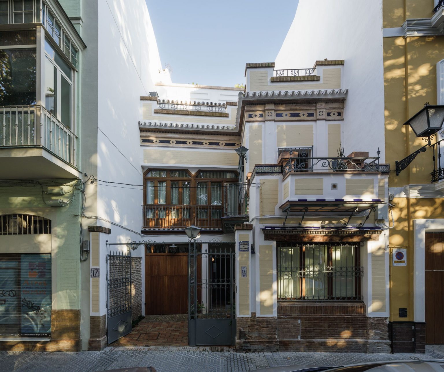 Fachada de la casa en una calle estrecha, con miradores y forja, en Casa Sonsoles