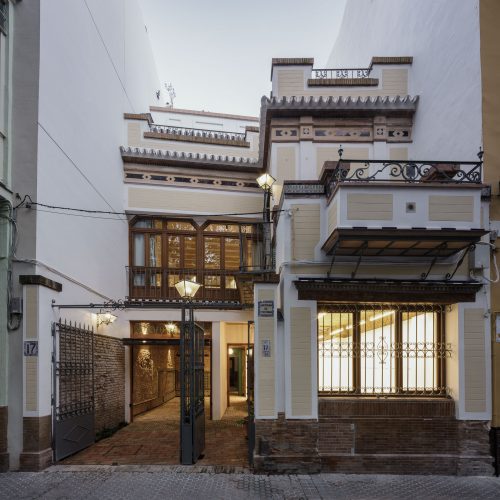 Fachada de Casa Sonsoles con mirador de madera y zaguán abierto iluminado