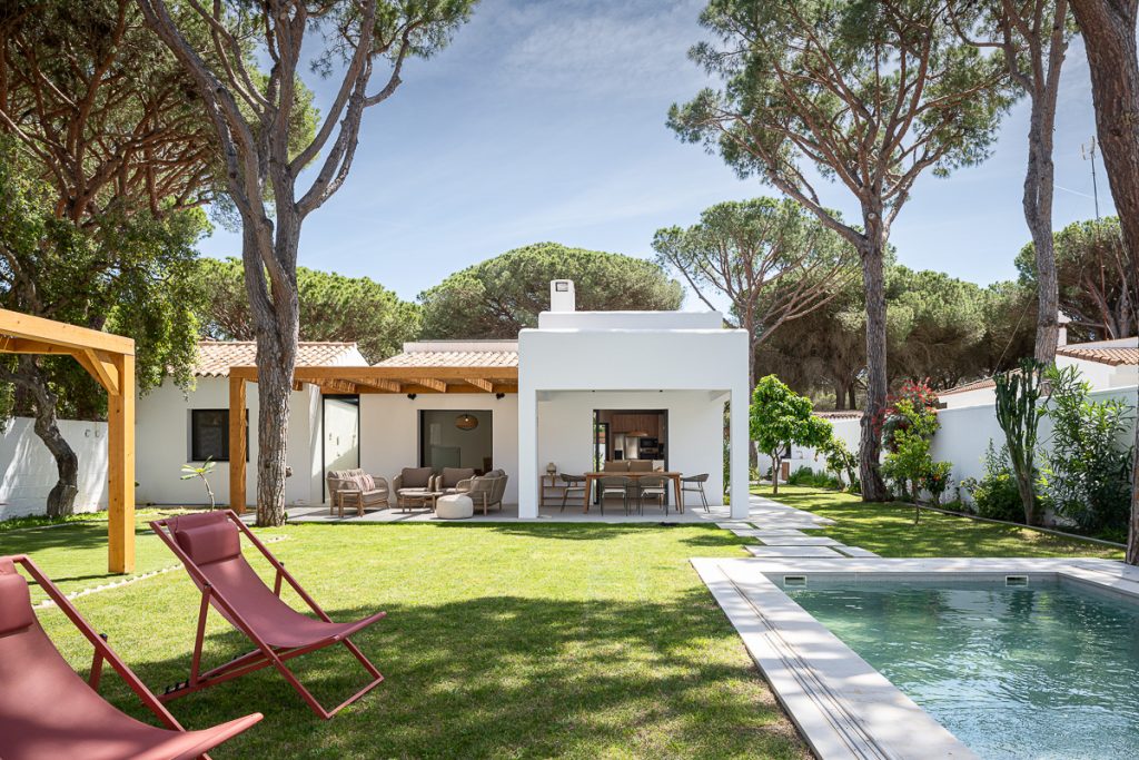 Jardín con piscina, pinos y porche de la Casa La Morena