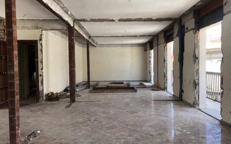 Vivienda vaciada en obra con pilares metálicos, suelo de mármol y ventanales al balcón